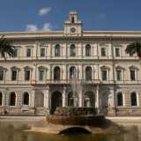 Giungiamo di fronte all'ingresso principale dell'Ateneo, posizionato in piazza Umberto. La monumentale costruzione, a pianta rettangolare, si presenta con una facciata di un delicato color crema e si articola su tre livelli
